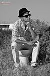 Gustavo sentado al aire libre con gorra, en una fotografía en blanco y negro de tono tranquilo.