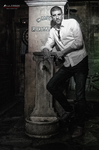 Gustavo posa en blanco y negro junto a una columna, con camisa clara y actitud serena.