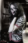 Esther posa en blanco y negro con gafas, blusa estampada y gesto pensativo en un ambiente de bar.