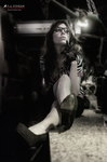 Esther posa en blanco y negro sentada en un bar, con gafas y gesto serio.