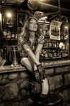 Esther sentada sobre una barra en una fotografía de estilo antiguo y ambiente de taberna.