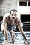 Manuel sale del agua en una piscina, con expresión concentrada y gotas sobre el cuerpo.