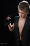 Modelo masculino con traje oscuro, fotografiado sobre fondo negro.
