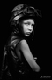 Retrato en blanco y negro de modelo femenina con sombrero y mirada lateral.