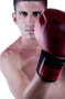 Modelo masculino con guante de boxeo rojo, en una imagen deportiva de estudio.
