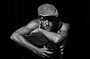 Modelo masculino en blanco y negro con gorra, posando con actitud fuerte.