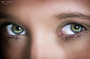 Primer plano de ojos verdes de modelo femenina, con mirada directa y luz suave.