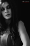 Retrato oscuro en blanco y negro de modelo femenina con mirada melancólica.
