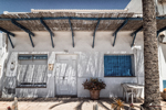 Fachada blanca con ventana azul en Carboneras, detalle de arquitectura mediterránea junto a la costa.
