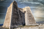 Construcción histórica de piedra en Carboneras, con muros antiguos y cielo nublado sobre la costa de Almería.