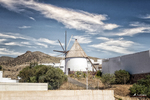 Molino tradicional en Carboneras, rodeado de paisaje seco, montañas y cielo azul en Almería.