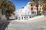 Calle de Carboneras con casas blancas, palmeras, cielo azul y arquitectura tradicional de la costa almeriense.