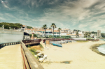 Playa de la Costa de Mijas con barcas, arena clara, paseo litoral y edificios junto al mar.
