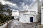 Edificio blanco en Rota bajo cielo nublado, con palmeras y arquitectura sencilla de la costa gaditana.