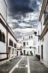Calle estrecha del casco antiguo de Rota, con casas blancas, suelo empedrado y perspectiva profunda.
