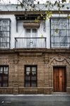 Fachada antigua con balcón y plantas en el casco histórico de Rota, Cádiz.