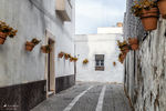 Rincón del casco histórico de Rota con calle estrecha, macetas y paredes encaladas.
