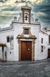Fachada de pequeña iglesia o capilla en Rota, Cádiz, con portada blanca y espadaña.