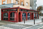 Fachada roja de un bar o restaurante en Rota, con ventanales amplios y esquina urbana.