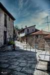 Calle empedrada de un pueblo del norte de España, con casas de piedra y arquitectura tradicional.