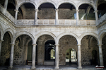 Claustro de piedra con arcos en un monasterio del norte de España, con luz suave y arquitectura histórica.
