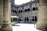 f.Patio interior de monasterio o edificio histórico en el norte de España, con arcos de piedra y suelo empedrado.