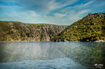 Río entre montañas verdes en el norte de España, paisaje natural de agua tranquila y laderas arboladas.