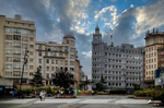 Plaza urbana del norte de España con edificios altos, farolas y cielo abierto.