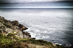 Acantilado y mar abierto en la costa atlántica del norte de España, con rocas y horizonte gris.