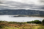 Bahía del norte de España vista desde un mirador, con mar, montañas y cielo nublado.