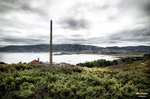 Paisaje costero del norte de España con chimenea alta, vegetación atlántica y cielo gris.
