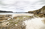 Playa salvaje del norte de España con rocas, arena clara y horizonte marino.