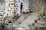 Escalinata de piedra junto a una casa tradicional en el norte de España, con macetas y muro antiguo.