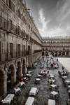 Plaza porticada en blanco y negro en una ciudad histórica del norte de España, con terrazas y arquitectura monumental.