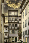 Fachada estrecha con balcones en el casco histórico de Oporto, Portugal, bajo un cielo dramático.