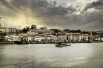 Ribera del río Duero en Oporto al atardecer, con edificios junto al agua y luz dorada.