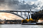 Puente sobre el río Duero en Oporto, con gran arco metálico y paisaje urbano al fondo.