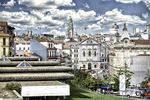 Vista de tejados y edificios históricos de Oporto, con fachadas blancas y cielo lleno de nubes.