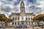 Ayuntamiento de Oporto en una plaza amplia, con fachada monumental, torre y cielo dramático.