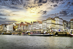 Ribeira de Oporto al atardecer, con fachadas coloridas, río Duero y luz dorada sobre Portugal.