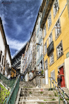 Escalera y fachada amarilla en una calle antigua de Oporto, con cielo azul y ambiente urbano.