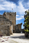 Torre medieval de piedra en el casco histórico de Chaves, Portugal, bajo un cielo azul.