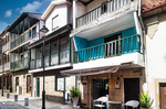 Calle de Chaves con galerías y balcones de madera, arquitectura popular y luz intensa.
