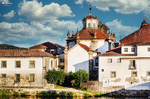 Conjunto histórico de Chaves junto al río Támega, con iglesia, tejados rojos y arquitectura portuguesa.