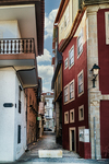Calle estrecha de Chaves con fachadas blancas y rojas, balcones y ambiente del casco antiguo.