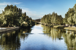 Río Támega en Chaves rodeado de árboles, con reflejos en el agua y paisaje sereno.