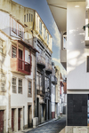 Calle con balcones tradicionales en Chaves, Portugal, con fachadas blancas y rojas del casco histórico.