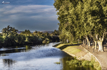 Ribera del río Támega en Chaves, con árboles, paseo peatonal y agua tranquila.
