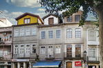 Edificio histórico de fachada blanca en Chaves, con ventanas ornamentadas y comercios en planta baja.