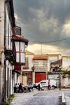 Plaza empedrada de Chaves con fachadas tradicionales, terraza y cielo de tormenta.